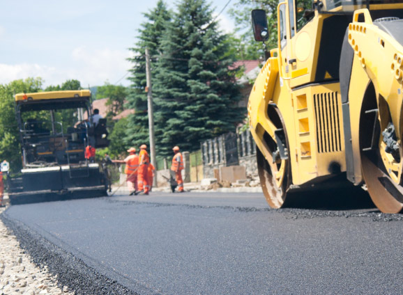 Construction workers paving a road